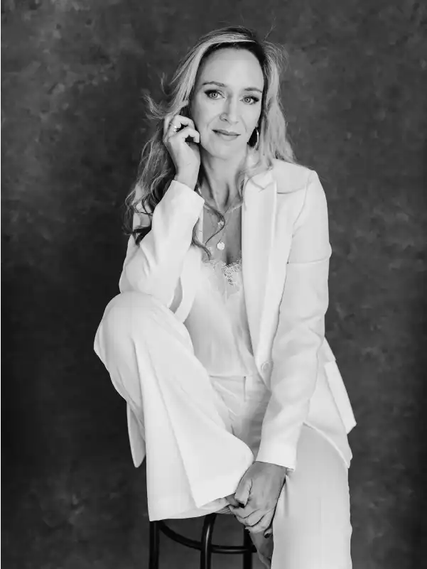 Christina von Hunnius, experienced Wedding Planner in Mallorca is posing for the camera, wearing an elegant white suite