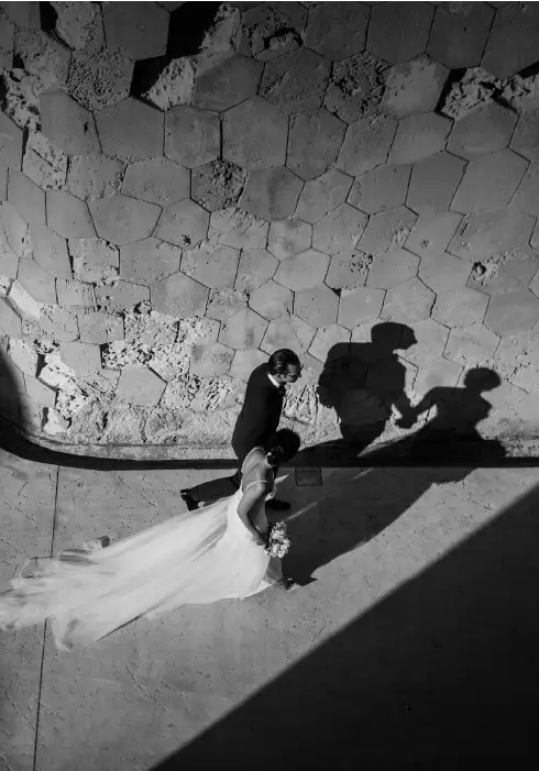 Bride and groom walk along the magical alleyways of Cap Rocat during their wedding in Mallorca
