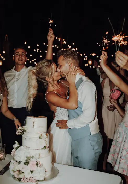 Couple kisses after cutting the wedding cake under the stars in Mallorca